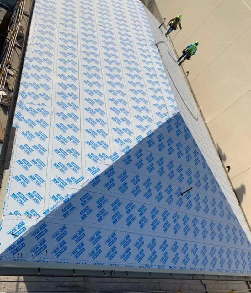 Professional roofers installing underlayment on a metal roof in Briar Chapel